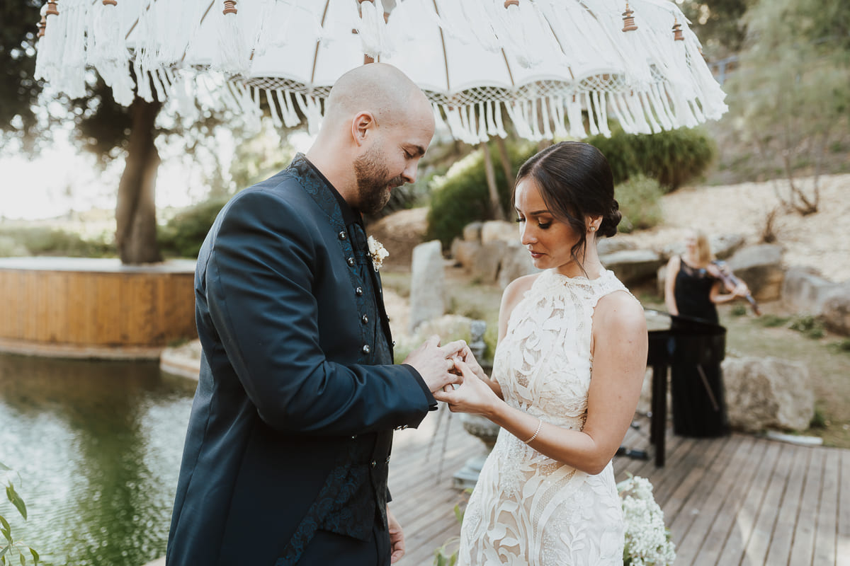 Novios cortando el pastel de boda rodeados de amigos y familiares